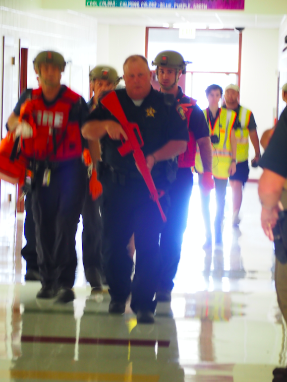 A security force escorts the first group of North Hays Fire/Rescue and EMS (medical support) personnel into the building.