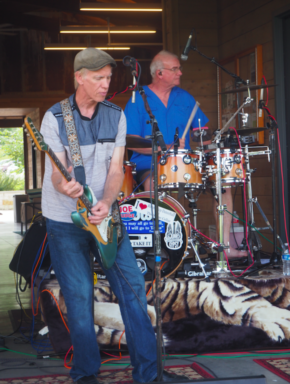 “Black Cat Choir” John Holmes played lead guitar, with drummer Jay Robinson behind him, during the car show.